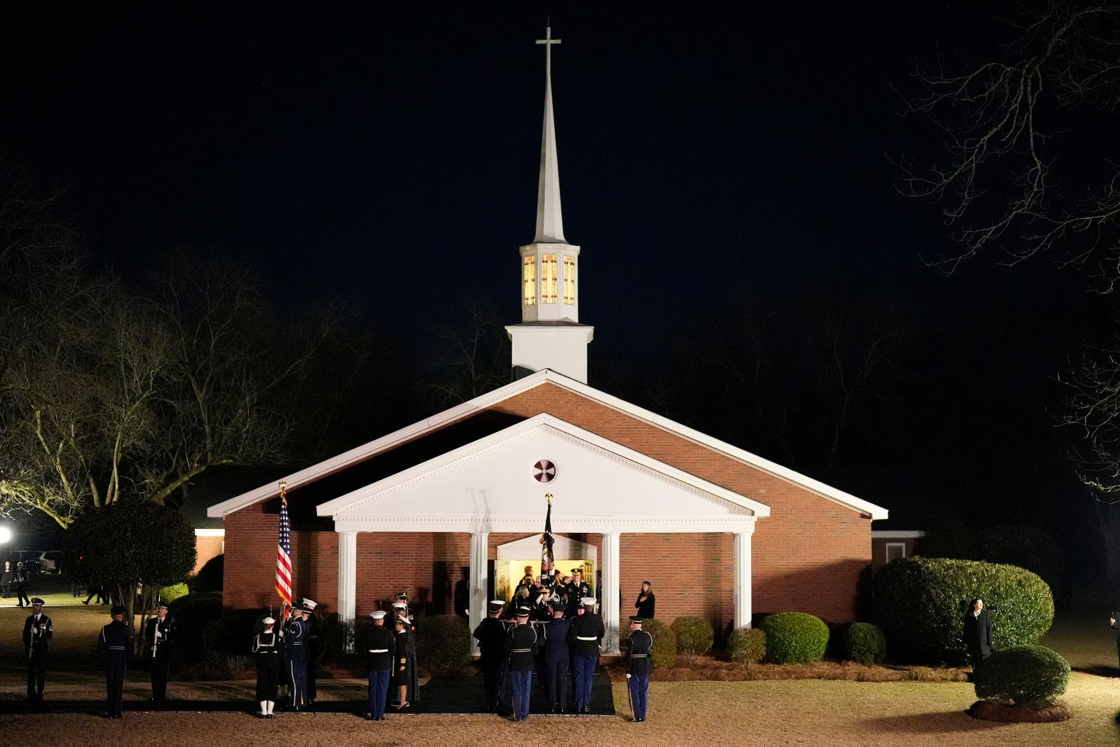 The flag-draped casket is carried to a hearse after Carter's funeral service at Maranatha Baptist Church.