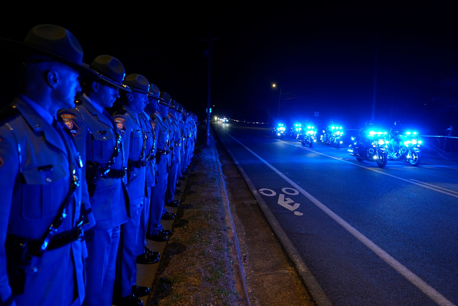 Law enforcement officials wait for the hearse carrying former President Jimmy Carter as it approaches the Carter residence, where he will be buried, in Plains, Georgia.