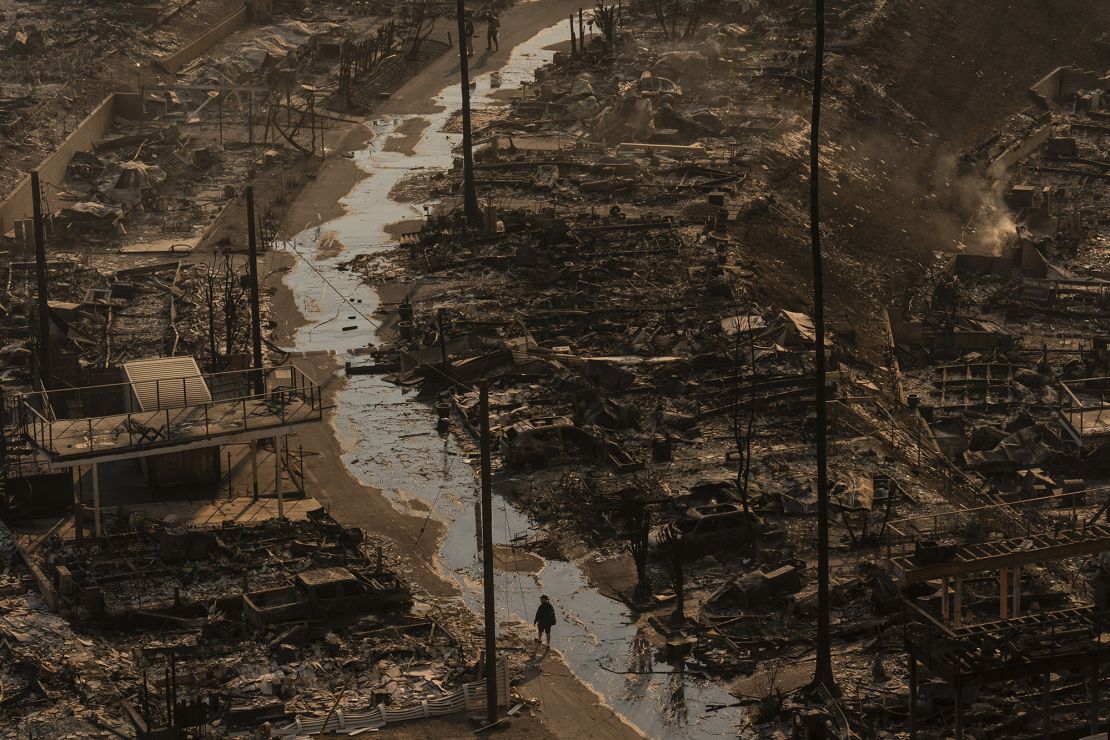 Een persoon loopt te midden van de verwoestingen die op 9 januari zijn achtergelaten door de Palisades Fire in Los Angeles.