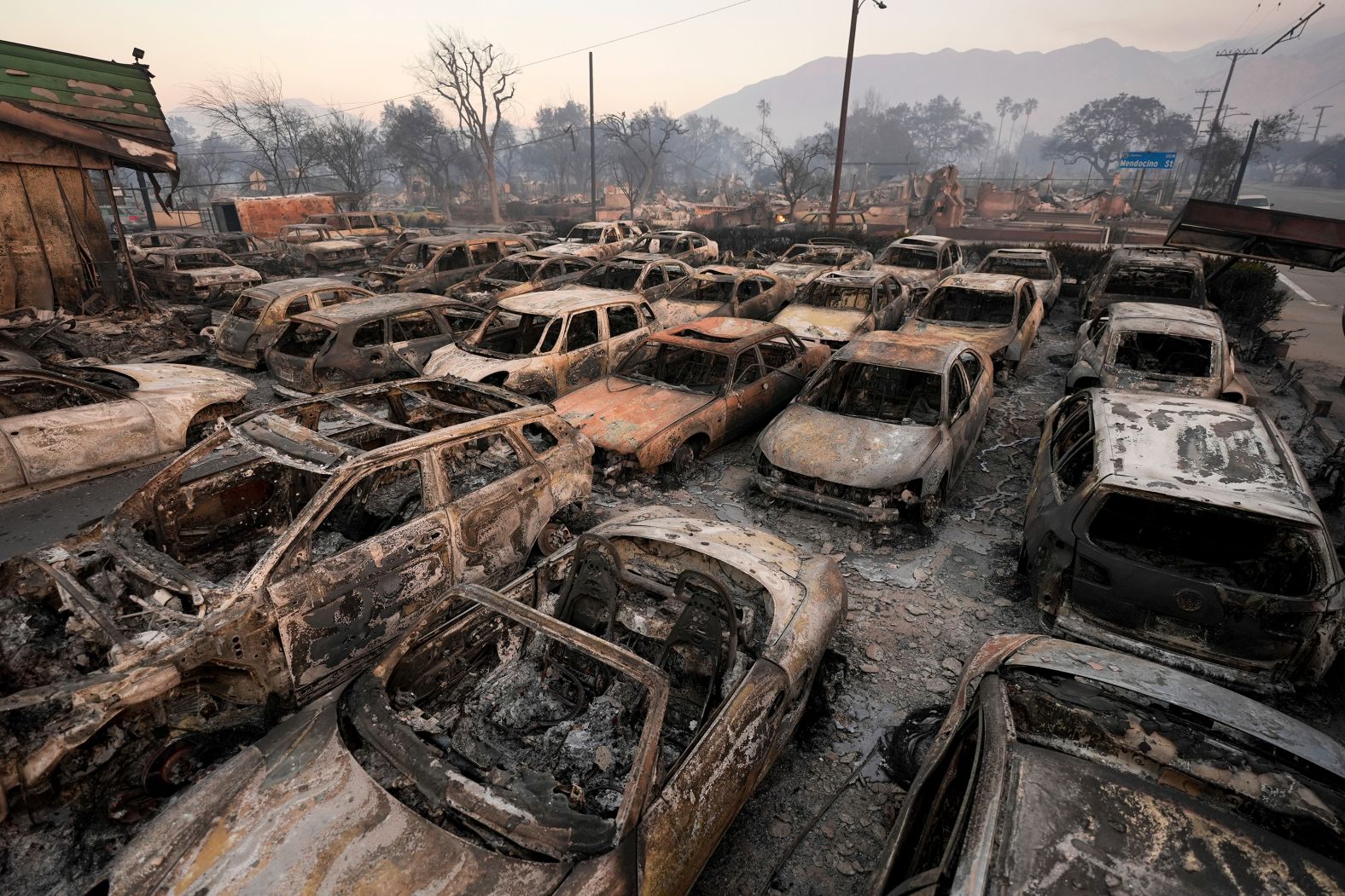 Vehicles charred by the Eaton Fire sit inside a dealership in Altadena.