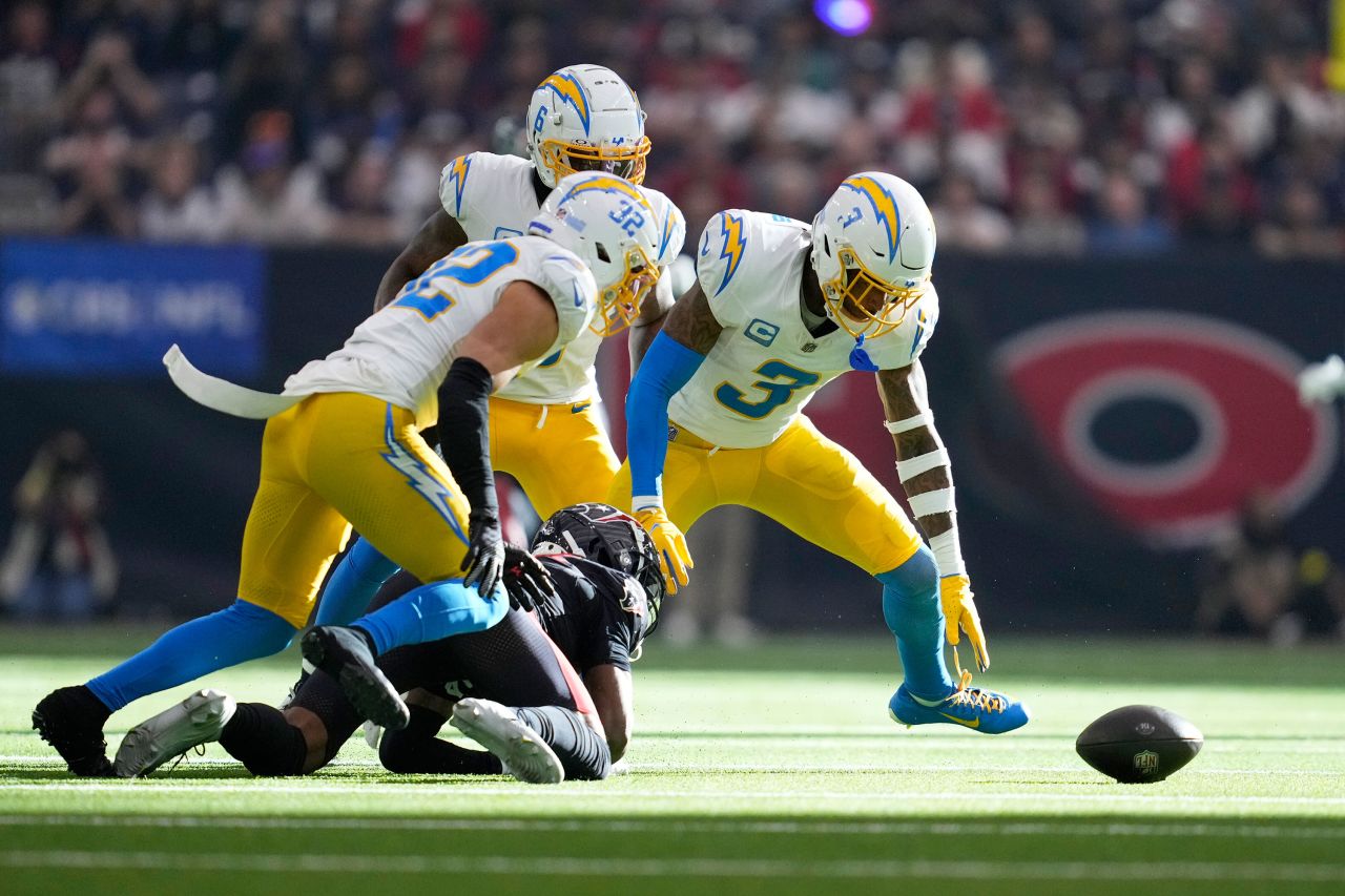 Los Angeles Chargers safety Derwin James reaches to recover a fumble by Houston Texans wide receiver John Metchie.