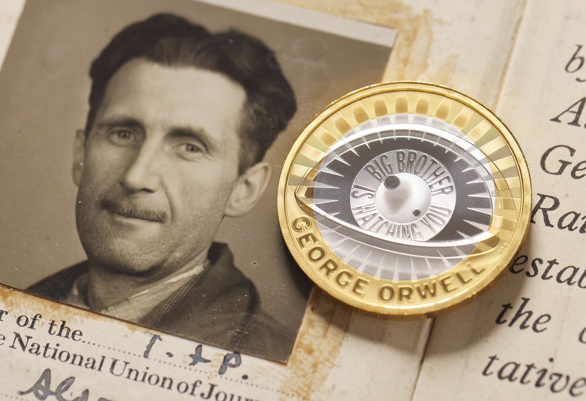 A photo of author George Orwell and the new £2 coin inspired by his work.