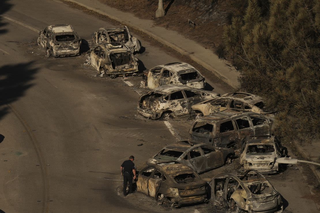 Agentes de policía inspeccionan coches abandonados en Sunset Boulevard durante el incendio de Palisades, en Palisades, California, el miércoles 15 de enero de 2025.