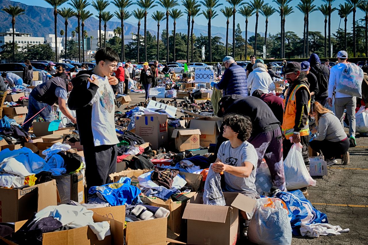 Ivan Benavidez, left, and his brother Isaac, who lost their home in the fires, look through boxes of donations in Arcadia, California on Wednesday.