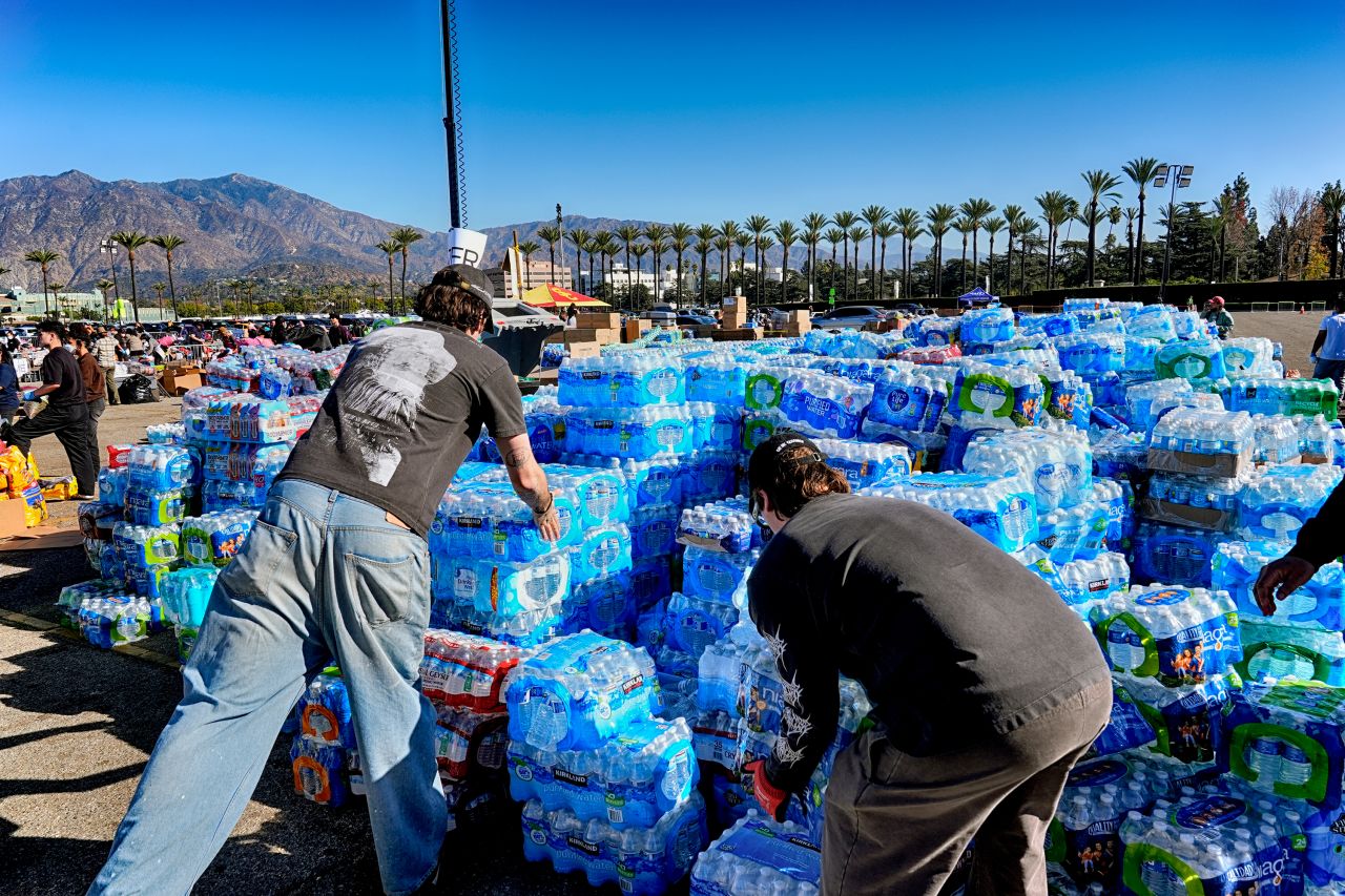 Volunteers stack water for people impacted by the Altadena Fire at a donation center in Arcadia, California on Wednesday.