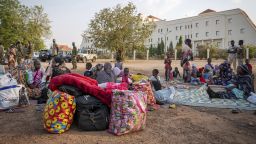 Sudanese nationals sit outside the South Sudan People's Defense Forces (SSPDF) headquarters, after a night of violence in Juba, South Sudan, on Friday, Jan. 17, 2025.