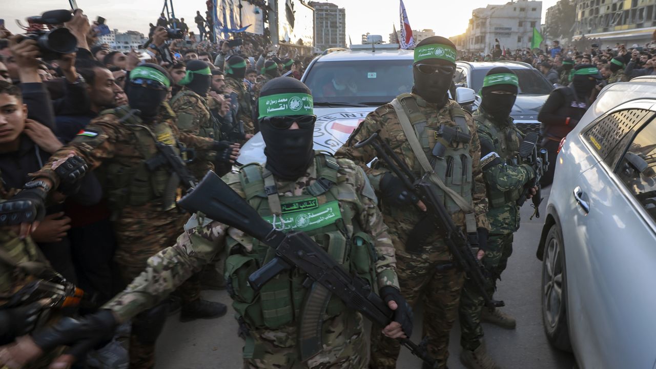 Hamas fighters escort a Red Cross vehicle to collect Israeli hostages released after a ceasefire agreement between Israel and Hamas took effect, in Gaza City Sunday, Jan. 19, 2025.