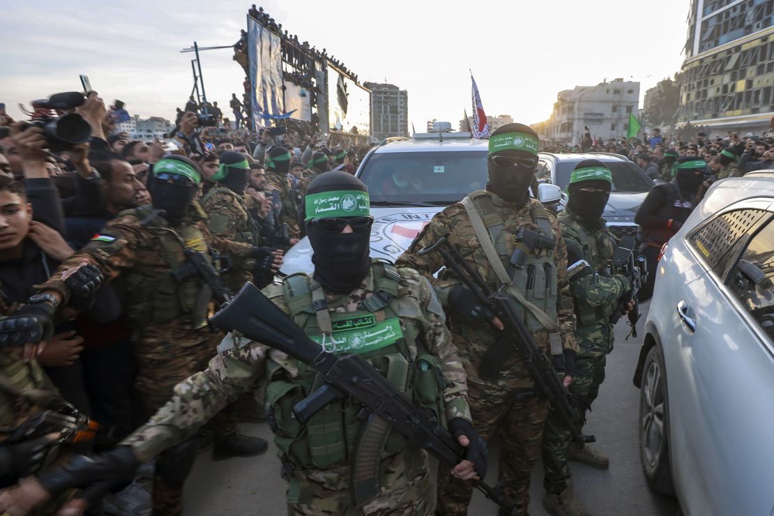 Militants from Hamas' military wing, the Qassam Brigades, escort a Red Cross vehicle to collect Israeli hostages in Gaza City on Sunday.