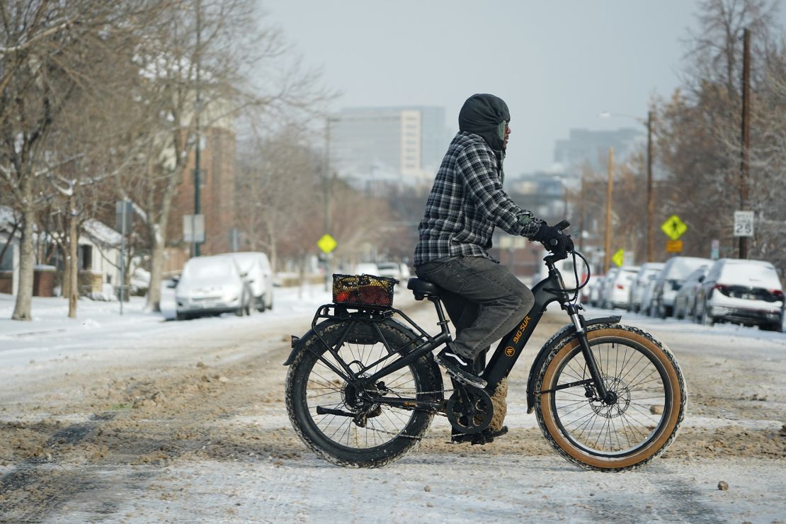 A bicyclist navigates 13th Avenue after a winter storm plunged daytime high temperatures into the single digits and left up to six inches of snow in its wake Monday in Denver.