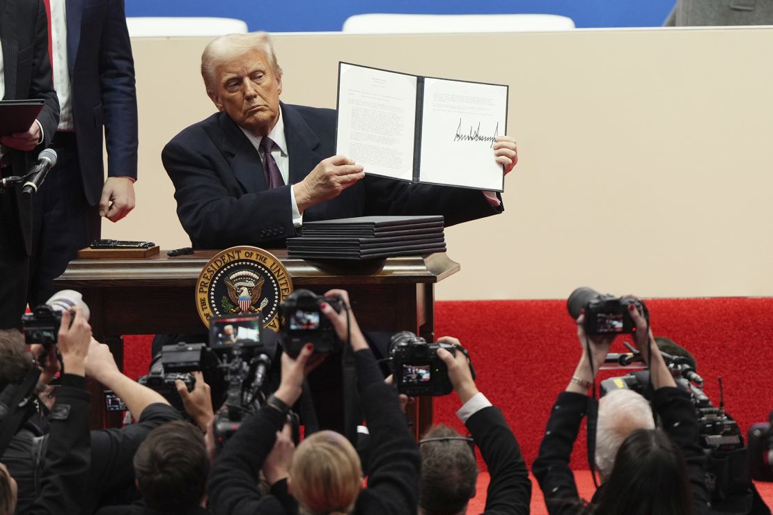 Trump holds an executive order after signing it during an inauguration event in Washington, DC, on Monday.