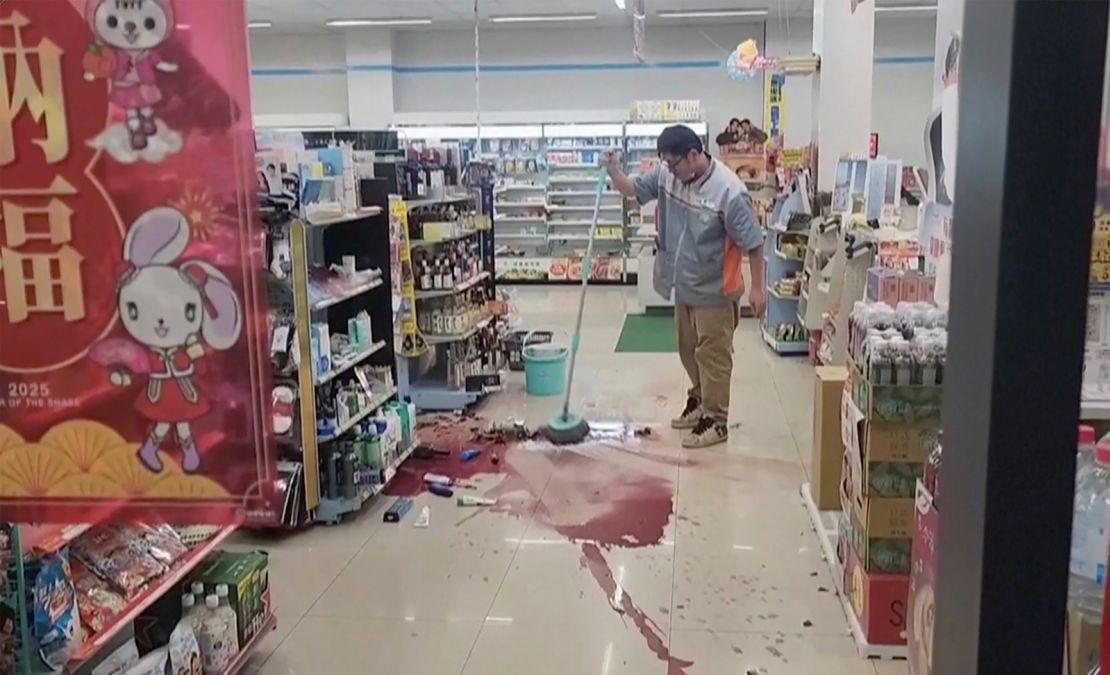 A store worker cleans the floor in Tainan after the earthquake.