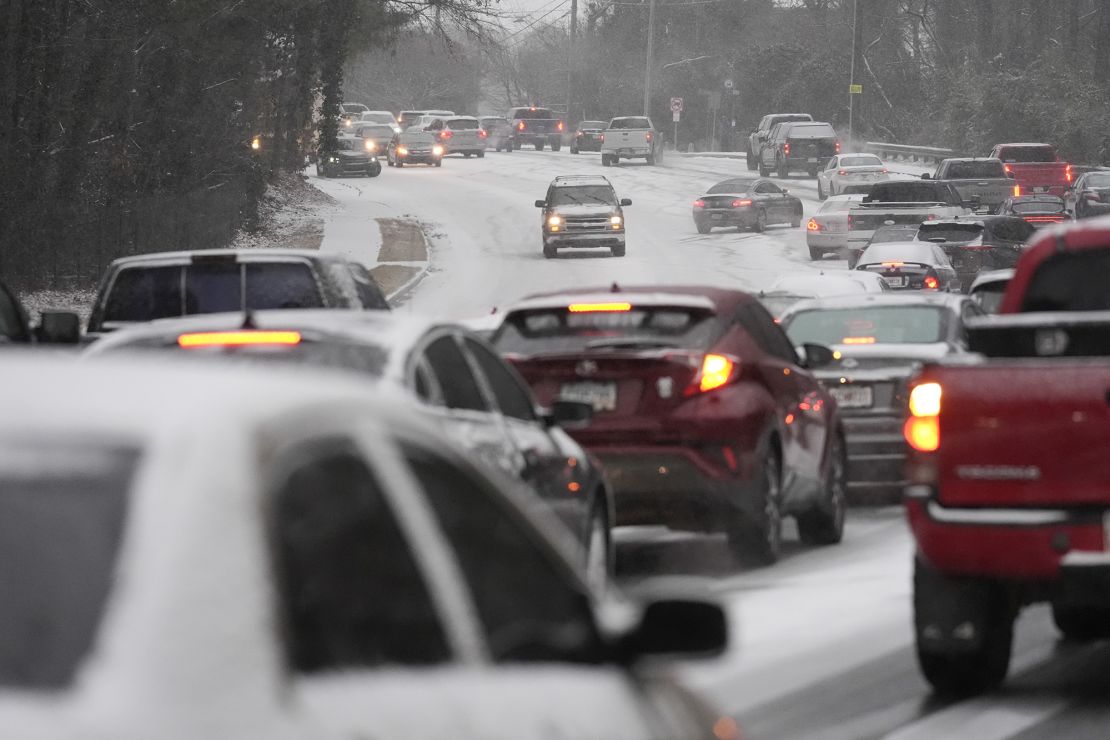 Cars backed up near a hill of snow and ice on the road during a winter storm Tuesday in Tucker, Georgia.