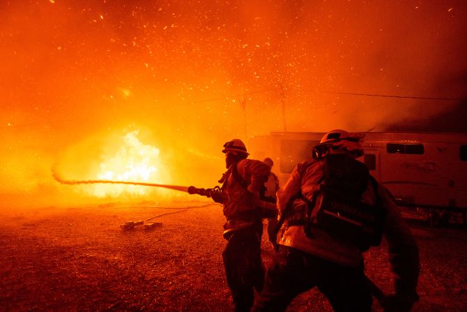 Firefighters spray water as they battle the Hughes Fire in Castaic.