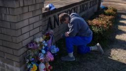 Kristi Rainwater kneels in prayer at a memorial for victims of a shooting at Antioch High School, Thursday, Jan. 23, 2025, in Nashville, Tenn. (AP Photo/George Walker IV)