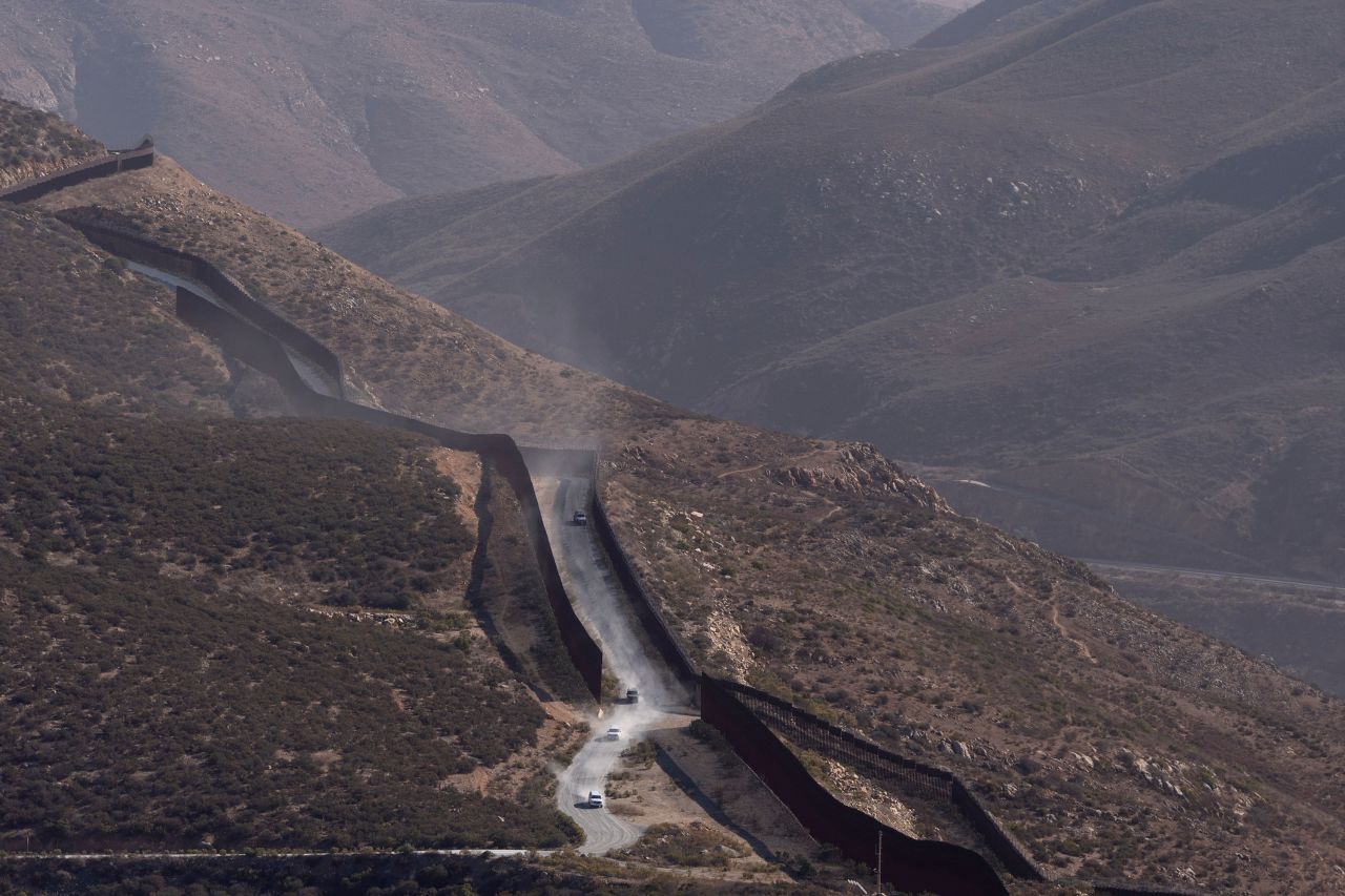 Border Patrol vehicles drive along two border walls separating Mexico from the United States in San Diego on Thursday.