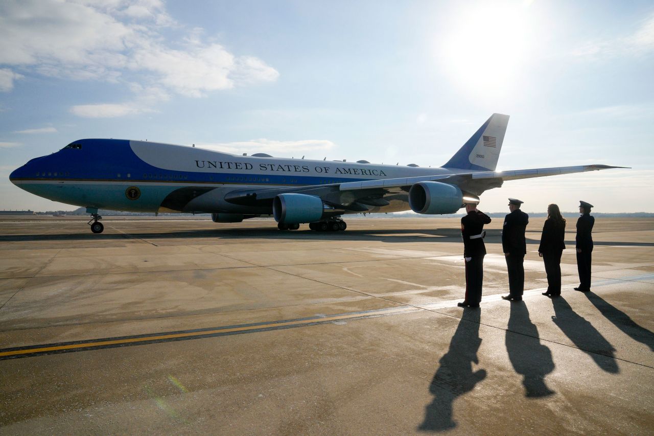 Two officers, alongside Protocol Specialist Christine Flessner and Col. Angela Ochoa, commander of the 89th Airlift Wing, salute as Air Force One takes off with President Donald Trump and first lady Melania Trump aboard at Joint Base Andrews, Maryland, on Friday.