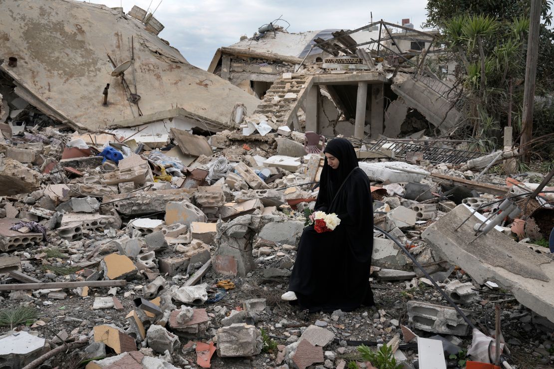 A Lebanese woman sits on the rubble of a house in Aita al-Shaab, a Lebanese border village, on January 26.