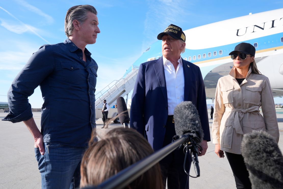President Donald Trump, center, speaks to California Gov. Gavin Newsom, left, after arriving at Los Angeles International Airport on January 24.