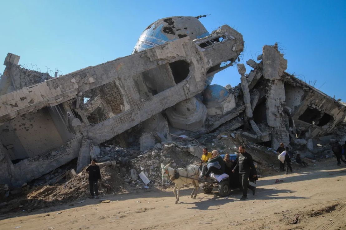 Una familia pasa en un carro tirado por caballos frente a una mezquita destruida en Beit Lahia, Gaza, el 29 de enero.