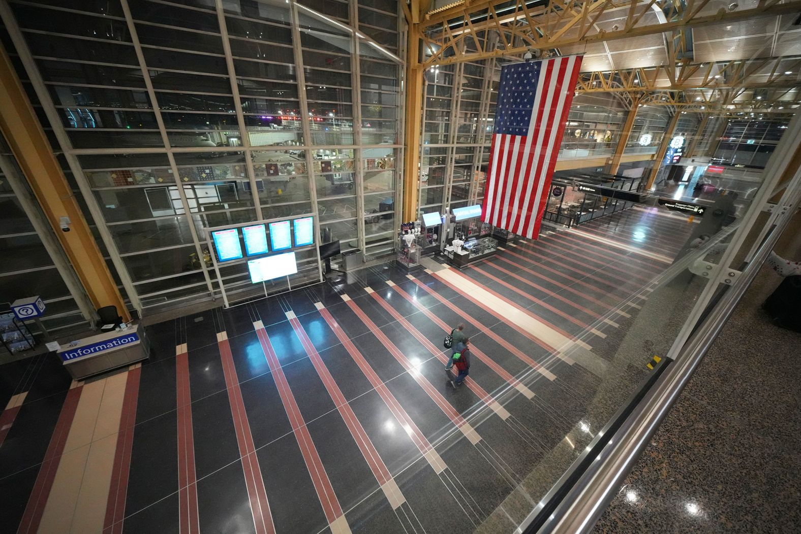 People walk through the virtually empty airport on Wednesday.