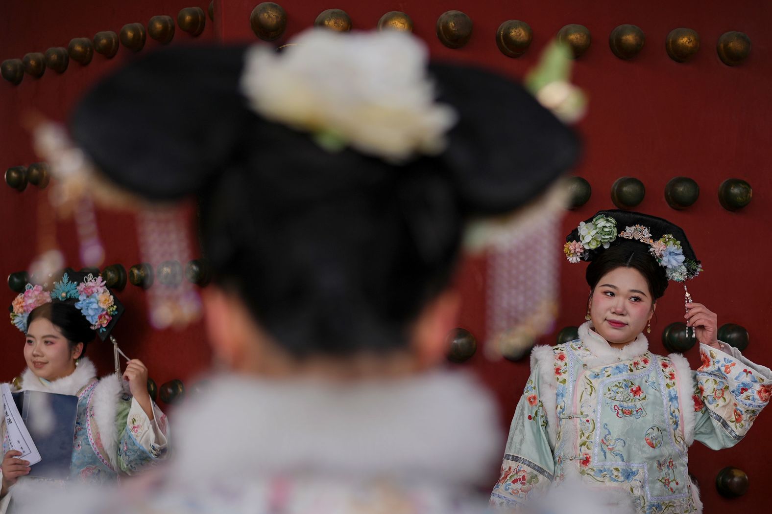 Women dressed in Qing Dynasty attire pose for photographs in Beijing's Forbidden City, during a week-long Lunar New Year holiday, on Thursday, January 30.