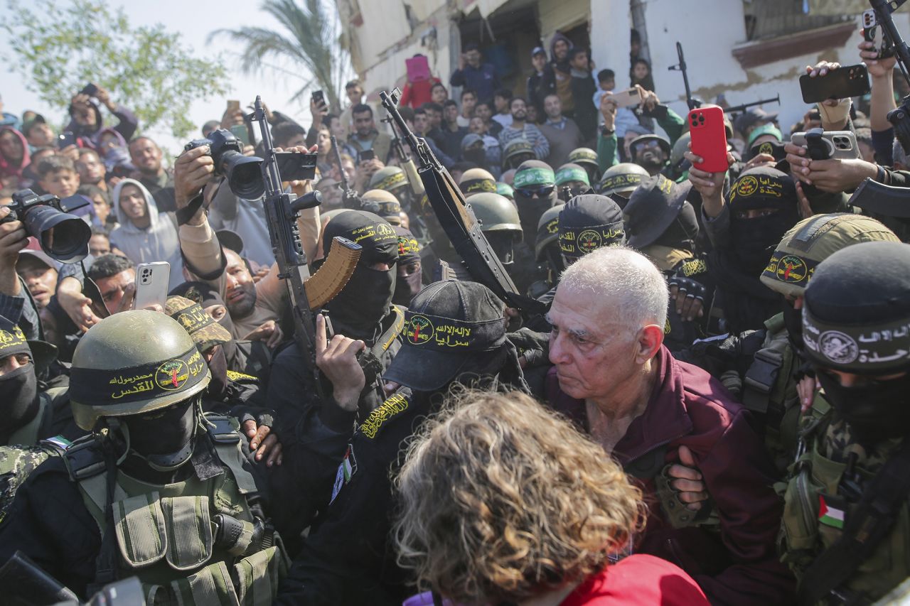 Gadi Mozes, center right, is escorted by Hamas and Islamic Jihad fighters as he is handed over to the Red Cross in Khan Younis, Gaza, on Thursday.