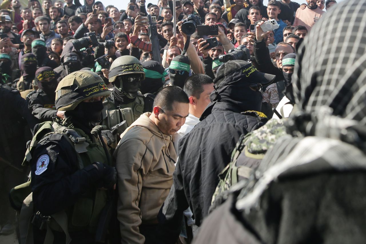 Two of the Thai hostages are escorted by Hamas fighters as they are handed over to the Red Cross in Khan Younis on Thursday.