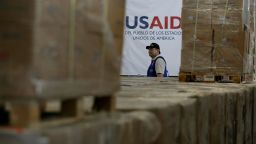 A man walks past boxes of USAID humanitarian aid at a warehouse at the Tienditas International Bridge on the outskirts of Cucuta, Colombia, on February 21, 2019.