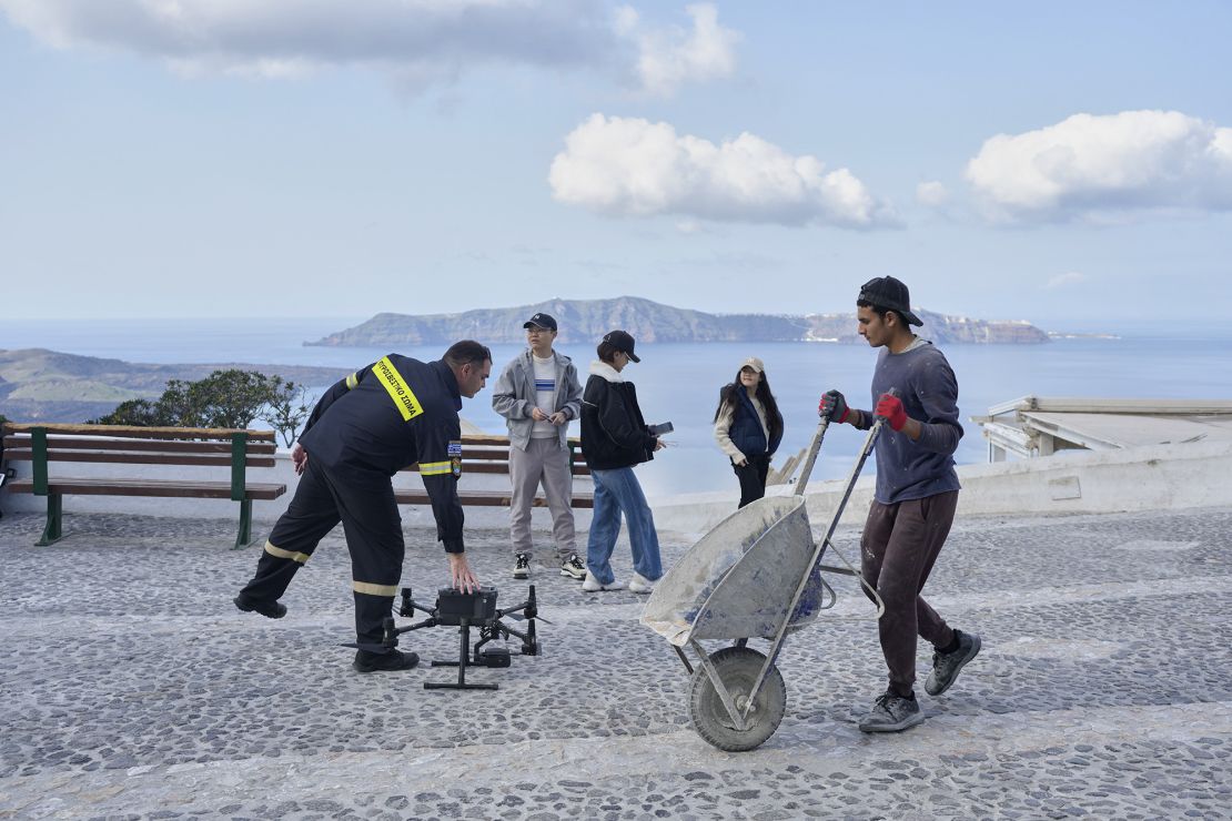 Los bomberos controlan drones para tomar medidas de emergencia en Santorini el lunes.