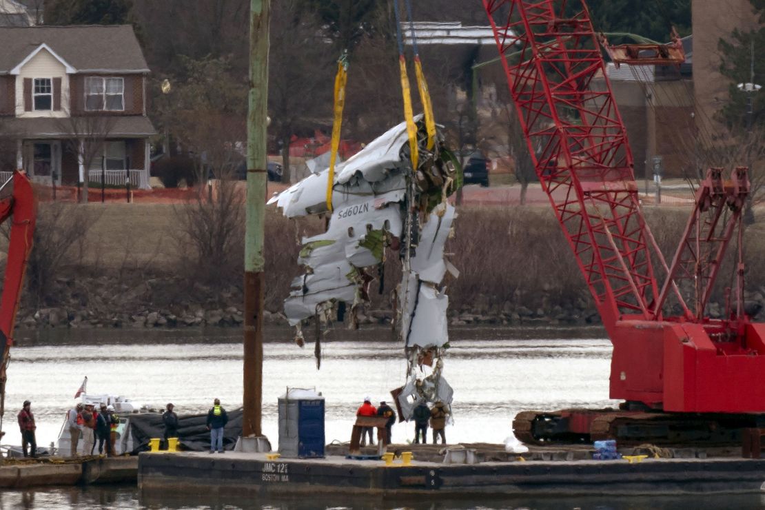 Crews pull up a part of the plane from the Potomac River near Ronald Reagan Washington National Airport on Monday in Arlington, Virginia.