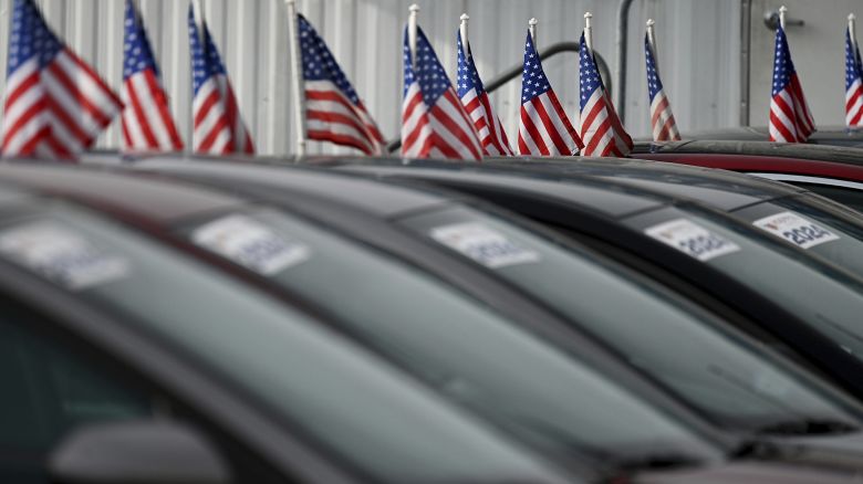 United States flags are set on used cars at a dealership in the Queens borough of New York City, NY, February 3, 2025. President Trump imposed 25% tariff on imports from Mexico and Canada due to take effect after midnight on February 2, but was reminded levies as both countries committed to enforcing control at their borders; Mexico agreed to send 10,00 troops and Canada invest $1.3b at the shared crossings. Canada is a large supplies of car parts.