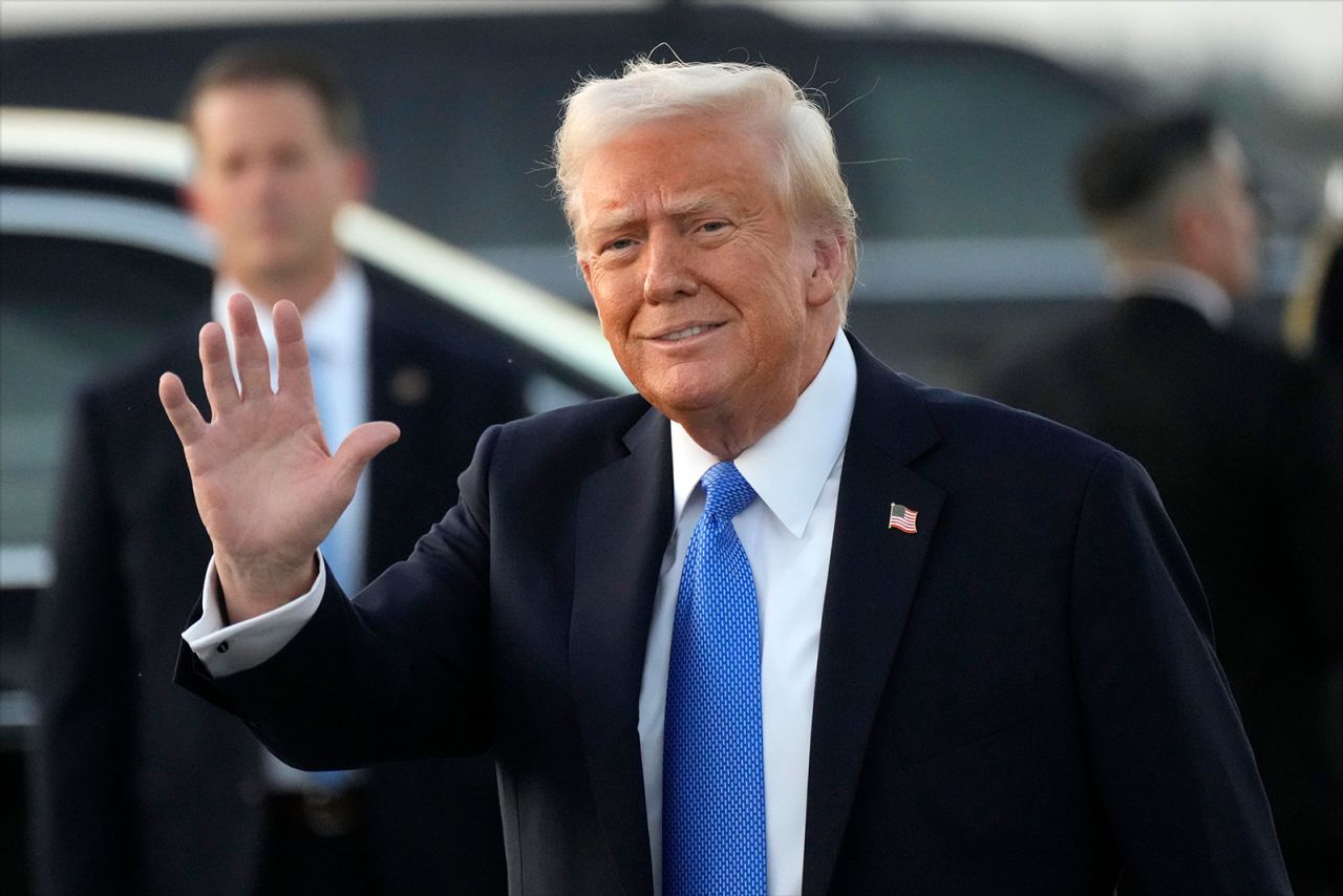 President Donald Trump waves after arriving on Air Force One at Palm Beach International Airport in West Palm Beach, Florida, on Friday.