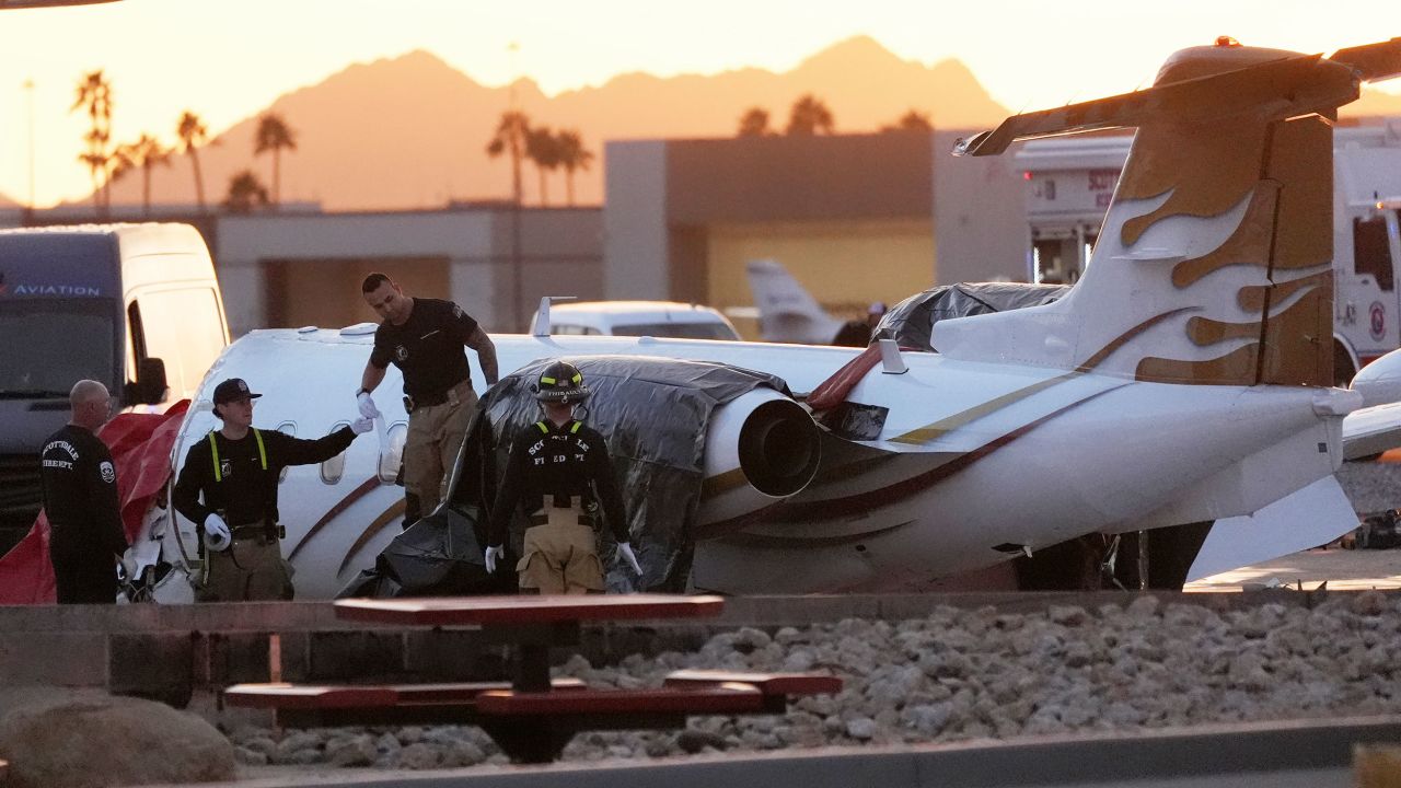 Scottsdale Fire Department firefighters work on a crashed Learjet at Scottsdale Airport after it crashed into another parked plane Monday, Feb. 10, 2025, in Scottsdale, Ariz. (AP Photo/Ross D. Franklin)