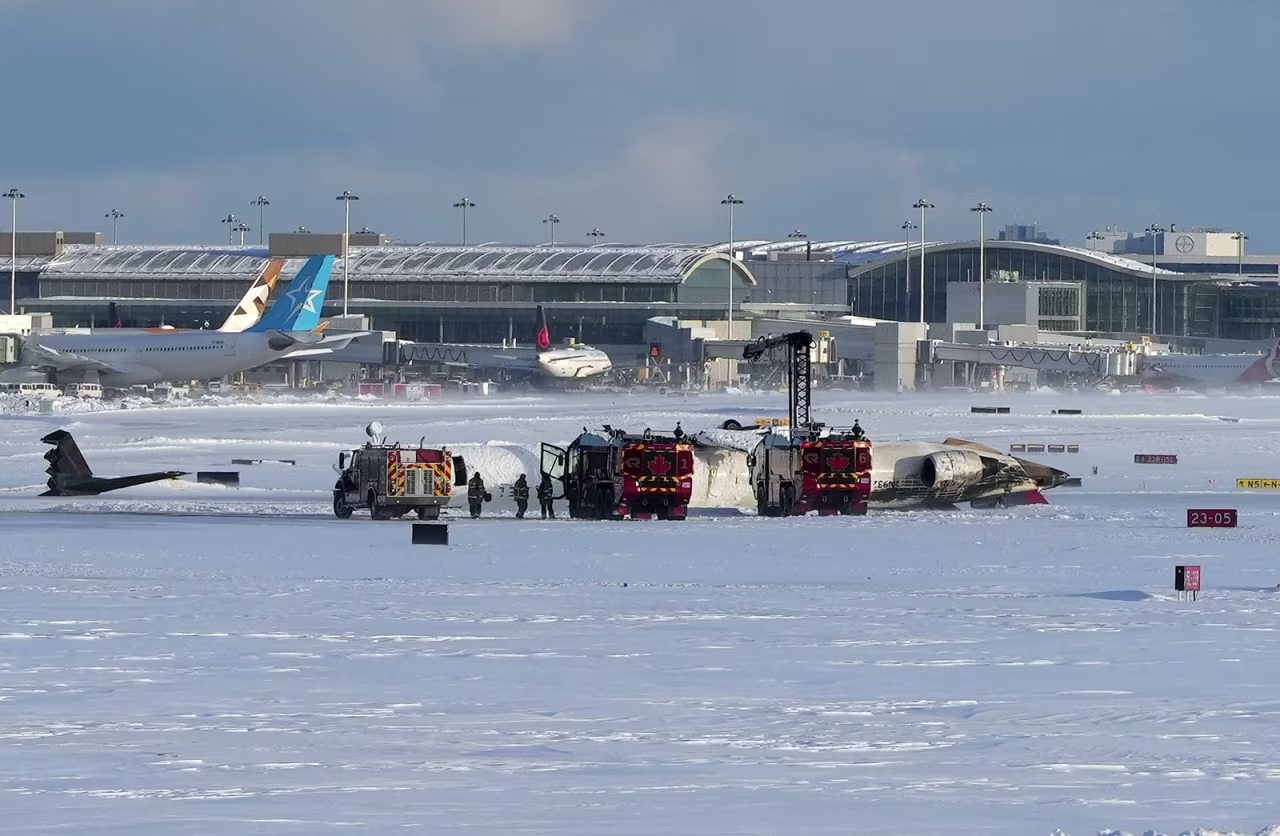 Pearson International Airport firefighters work on an upside down Delta Air Lines plane, which was heading from Minneapolis to Toronto when it crashed on the runway, in Toronto, on Monday.