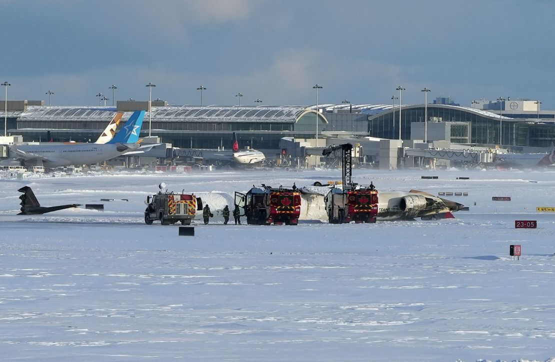 Firefighters at scene of overturned Delta Air Lines flight in Toronto on Monday.