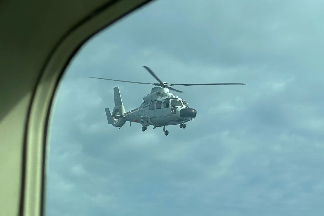 A Chinese military helicopter flies close to a Philippine Bureau of Fisheries and Aquatic aircraft above Scarborough Shoal in the South China Sea, on Tuesday, February 18, 2025.