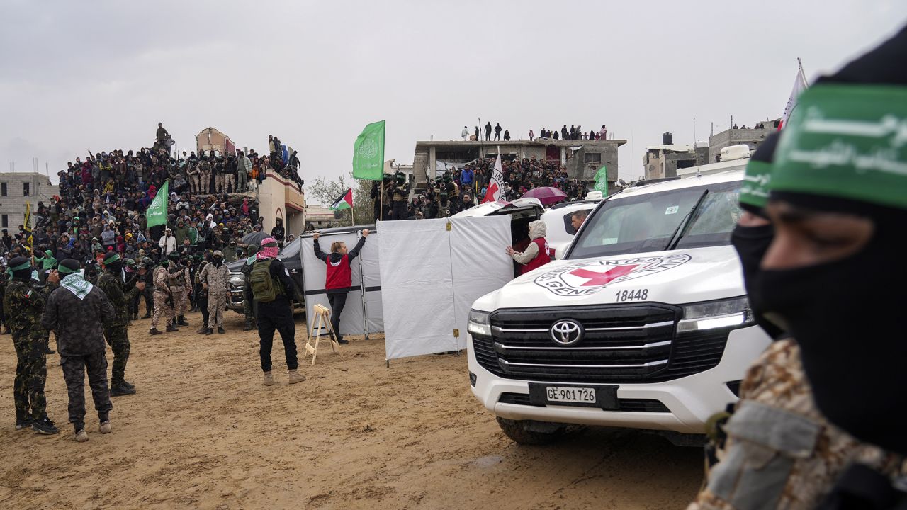 Palestinians gather as Hamas militants hand over coffins containing four bodies to the Red Cross in Khan Younis, southern Gaza Strip, Thursday, Feb. 20, 2025.  Israel has identified three of the bodies as hostages and said the other was of an unknown person. (AP Photo/Abdel Kareem Hana)