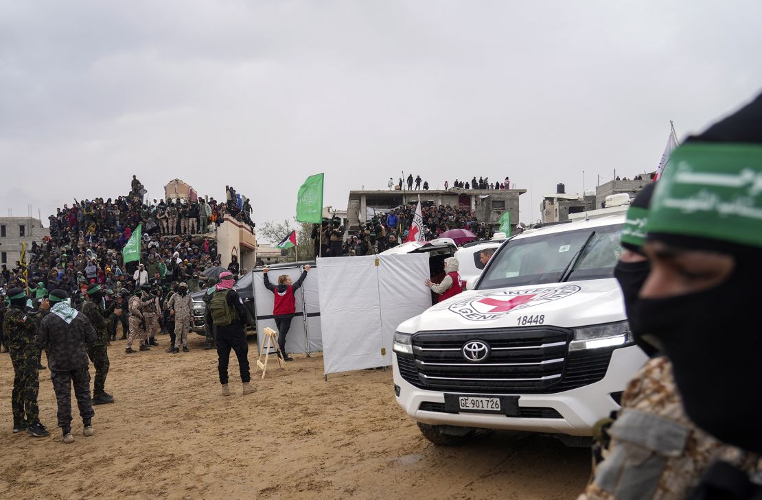 Palestinians gather as Hamas militants hand over coffins containing four bodies to the Red Cross in Khan Younis on February 20, 2025.