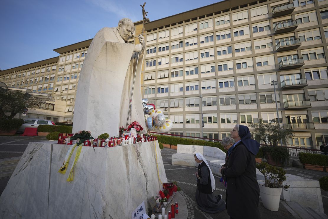 People have created a makeshift shrine for Pope Francis at a statue of John Paul II in front of the Gemelli Hospital in Rome.