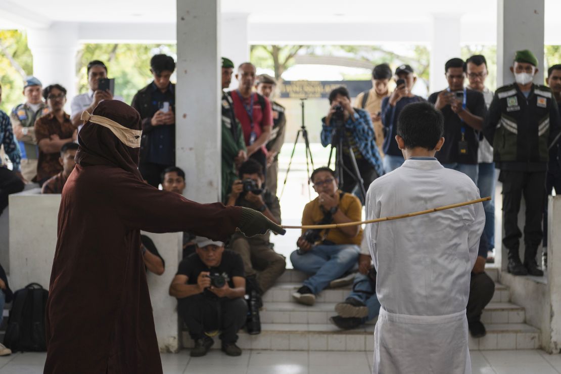 A Shariah law official uses a rattan cane to whip one of two men convicted of gay sex in Banda Aceh, Aceh province, Indonesia, Thursday, Feb. 27, 2025.