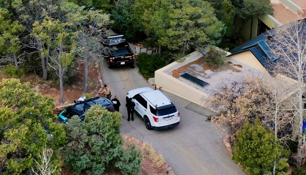 Law enforcement officials talk outside the home of Gene Hackman on February 27 in Santa Fe, New Mexico.