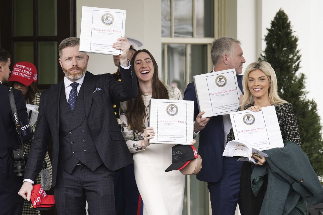 People carrying binders bearing the seal of the US Justice Department reading 