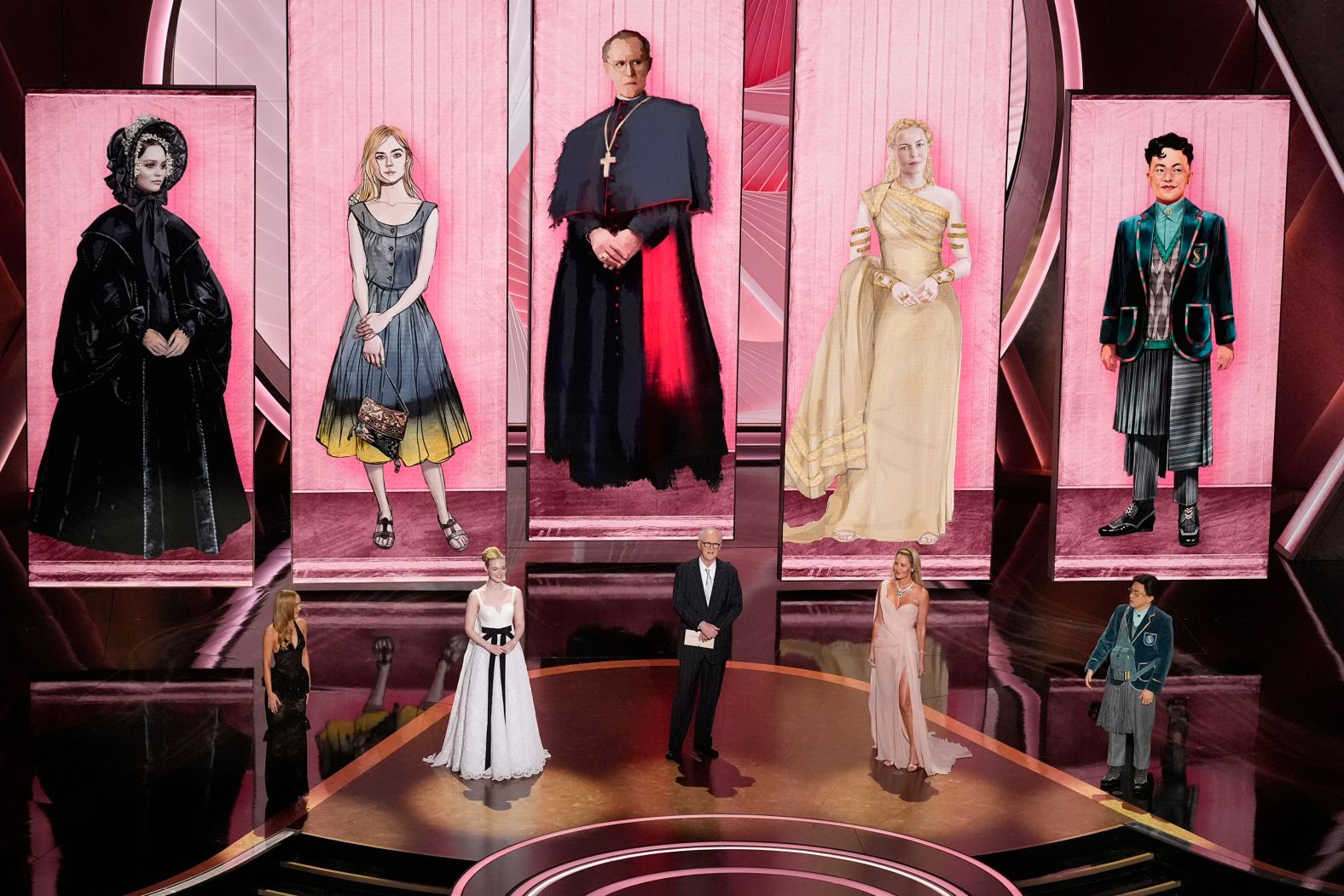 From left, Lily-Rose Depp, Elle Fanning, John Lithgow, Connie Nielsen and Bowen Yang present the Oscar for best costume design.