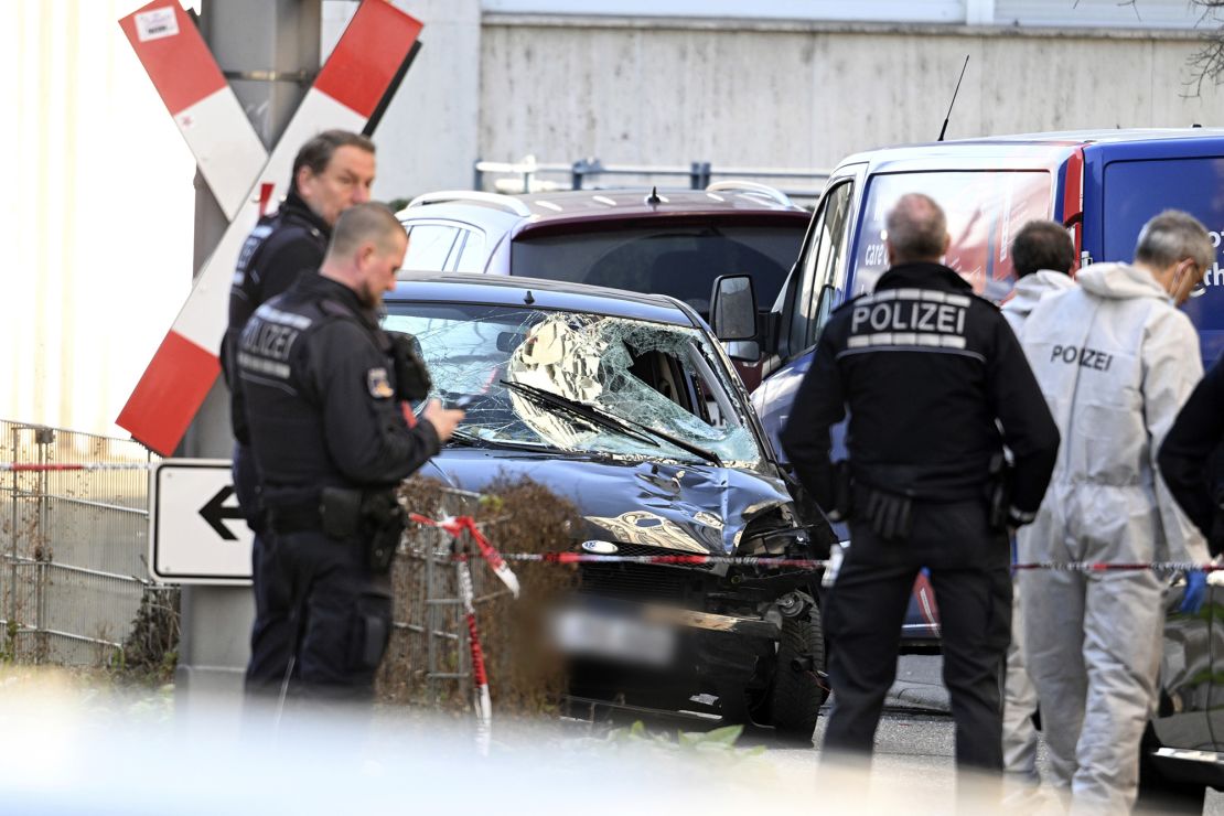 Officers inspect a damaged vehicle after the deadly incident on March 3.