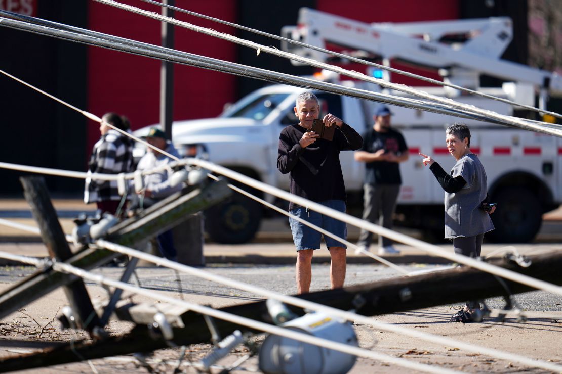 A person photographs a downed power line following an early morning storm in Irving, Texas, Tuesday.