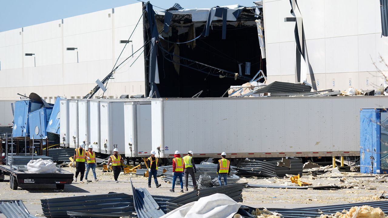 A workers walk outside a damaged warehouse after storms moved through Tuesday, March 4, 2025, in Lewisville, Texas. (AP Photo/LM Otero)