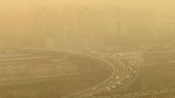 Seen through a glass window, cars drive along a highway during a dust storm amid heavy pollution in Beijing, on March 10, 2023.