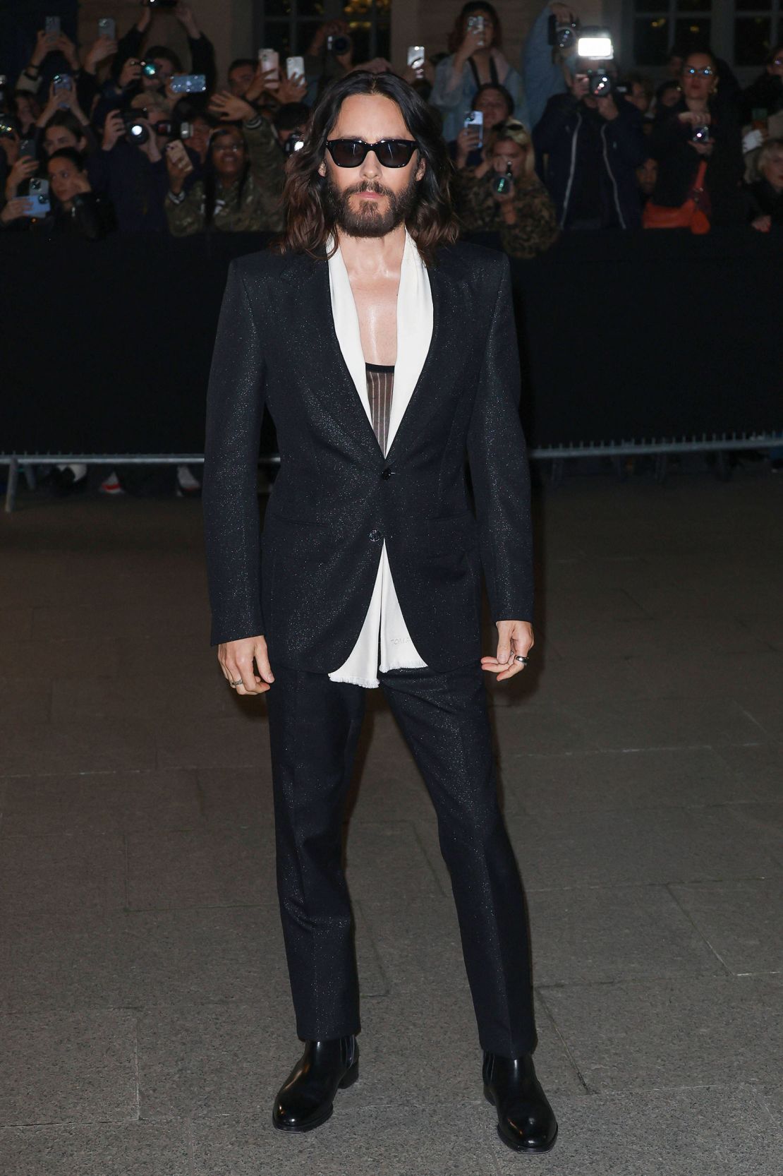 Actor Jared Leto outside the Tom Ford show in a shimmering blazer worn over a low cut top.