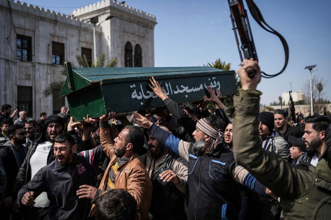 Syrian fighters and civilians carry the coffin of a member of the Syrian security forces during his funeral in Hama province, Syria on Sunday.