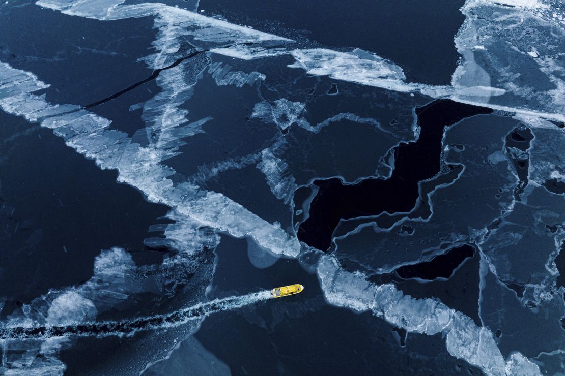 A boat rides though a frozen sea inlet outside of Nuuk, Greenland, Thursday, March 6, 2025.